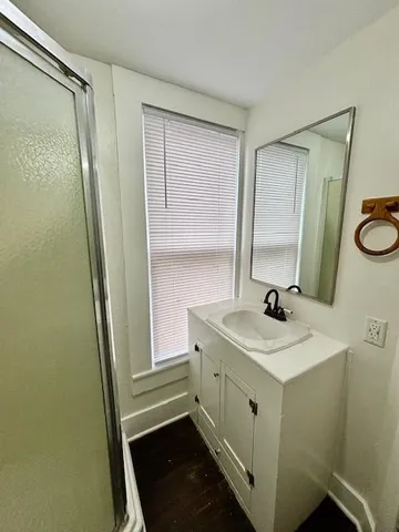 a view of empty room with wooden floor