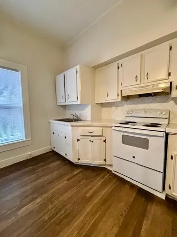 a kitchen with granite countertop white cabinets and white appliances