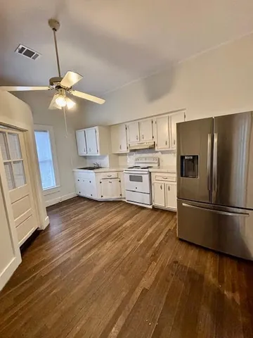 a kitchen with wooden floors and appliances