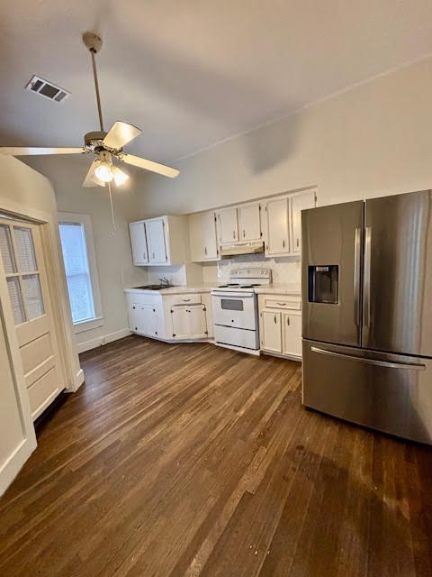 210 East Phillips Street Conroe, TX 77301 - Photo 10 of 27 a kitchen with stainless steel appliances a stove a refrigerator cabinets and wooden floor