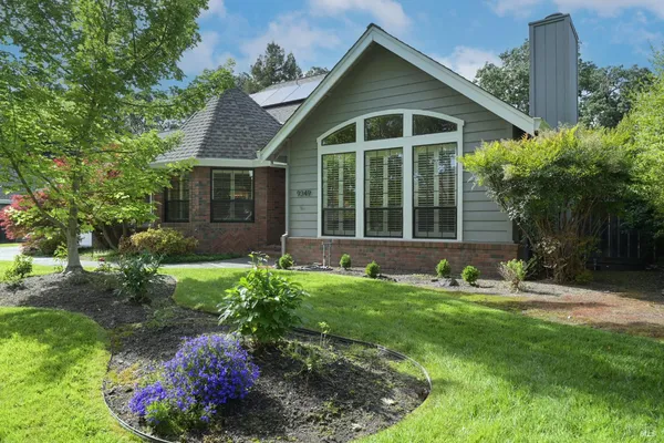 a view of a house with a yard and potted plants