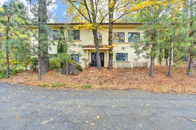 a view of a house with backyard and sitting area