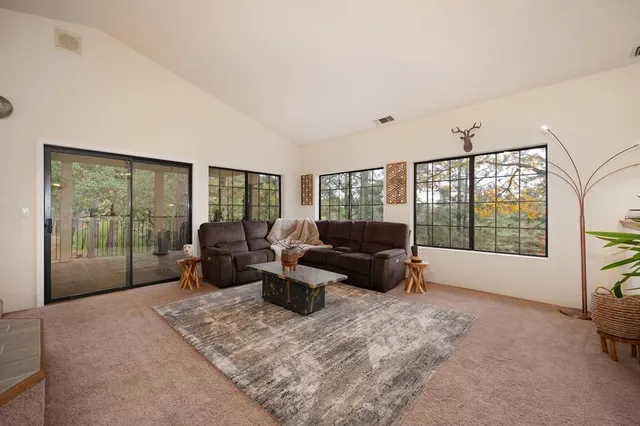 a dining room with kitchen island granite countertop furniture a large window and stainless steel appliances