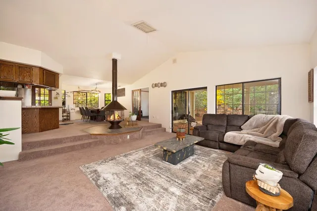 a large kitchen with a table chairs and flat screen tv