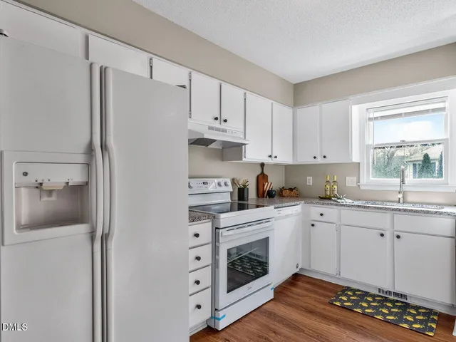 a kitchen with cabinets stainless steel appliances and a window