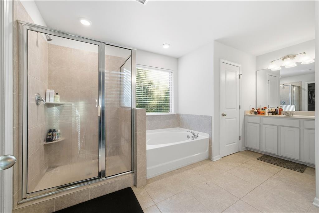 4000 Lake Manor Way Atlanta, GA 30349 - Photo 23 of 36 a bathroom with a large tub a sink shower and mirror