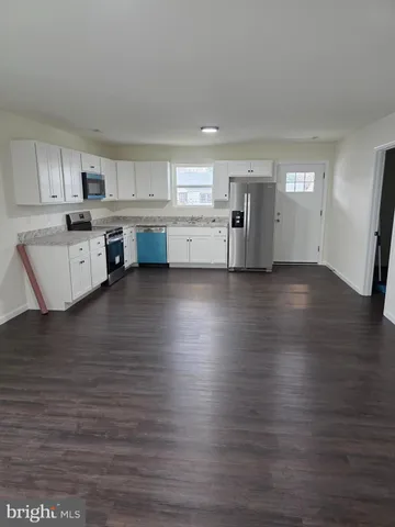 a view of open kitchen with wooden floor and electronic appliances
