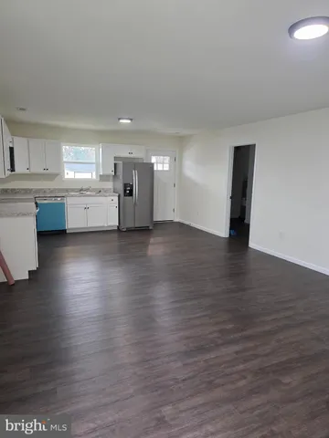 a view of a kitchen with wooden floor and a sink
