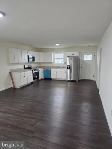 a view of a kitchen with wooden floor and electronic appliances