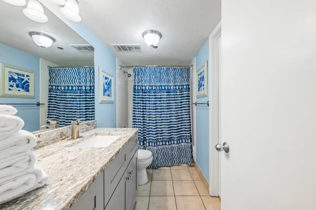 a spacious bathroom with a granite countertop sink a toilet and shower