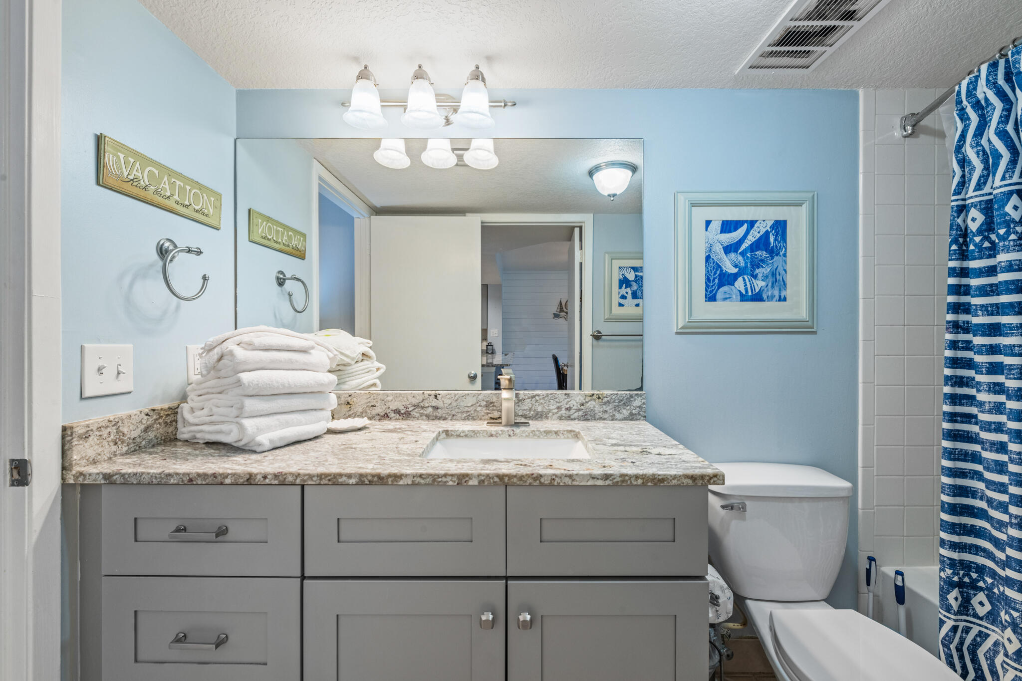 1114 Santa Rosa Boulevard, Unit 309 Fort Walton Beach, FL 32548 - Photo 18 of 52 a bathroom with a granite countertop toilet sink and mirror