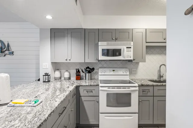 a kitchen with white cabinets stainless steel appliances and sink