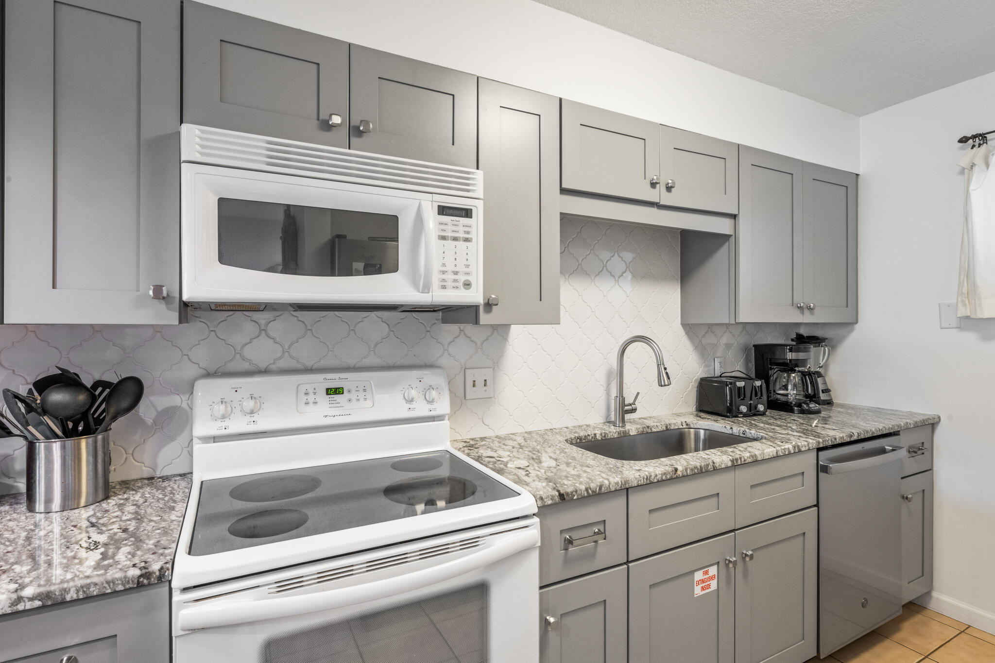 1114 Santa Rosa Boulevard, Unit 309 Fort Walton Beach, FL 32548 - Photo 21 of 52 a kitchen with white cabinets stainless steel appliances and sink