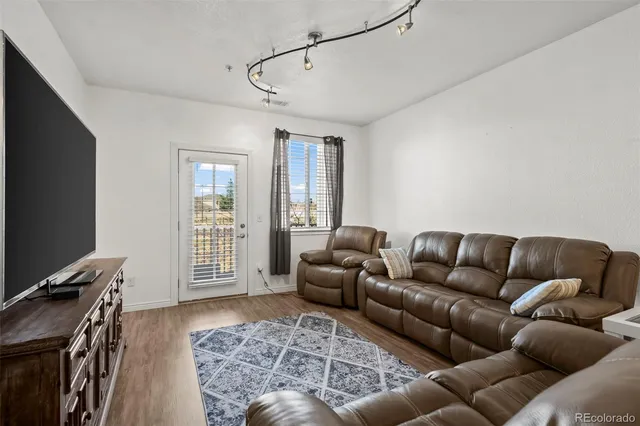 a living room with furniture a flat screen tv and a window