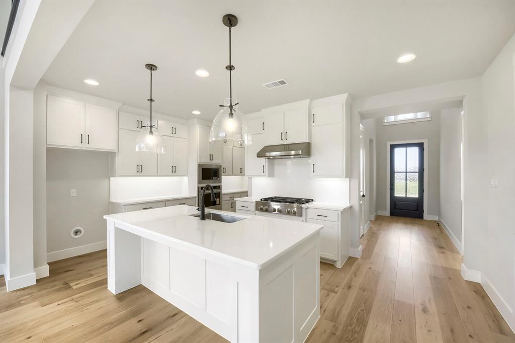 800 Blackberry Road Haslet, TX 76052 - Photo 7 of 28 Modern kitchen featuring white cabinetry, quartz countertops, a stainless steel gas range, and wood-finish flooring