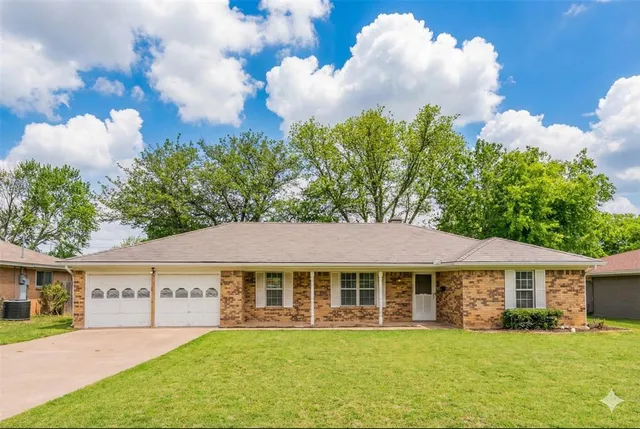 a view of a house with a yard and potted plants