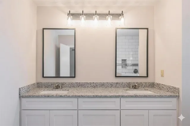 a bathroom with a granite countertop sink and a mirror