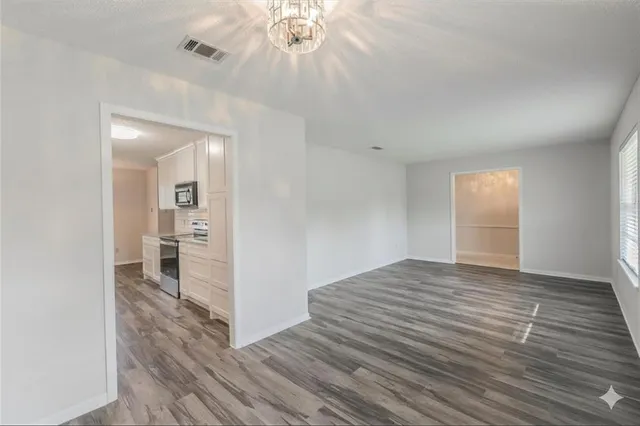 a view of a room with wooden floor and a window