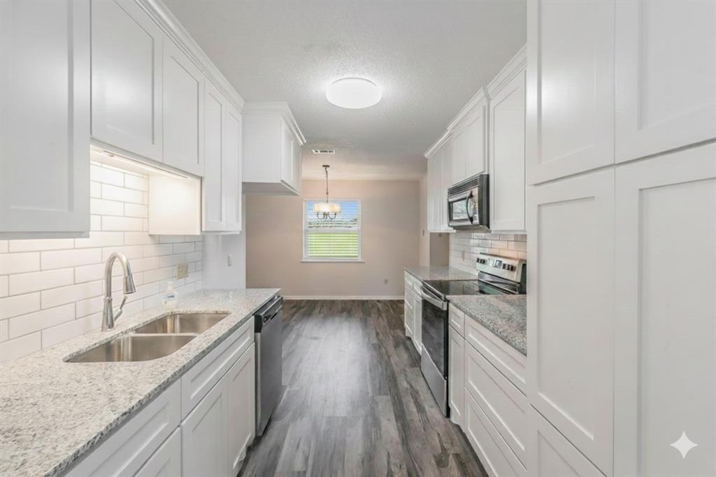 6248 Trail Lake Drive Fort Worth, TX 76133 - Photo 7 of 28 a kitchen with granite countertop a sink wooden floor and stainless steel appliances