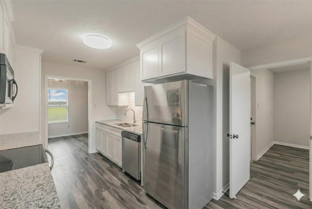6248 Trail Lake Drive Fort Worth, TX 76133 - Photo 8 of 28 a kitchen with a refrigerator a stove and wooden floor