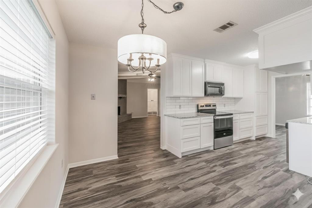 6248 Trail Lake Drive Fort Worth, TX 76133 - Photo 9 of 28 a large kitchen with cabinets wooden floor and stainless steel appliances