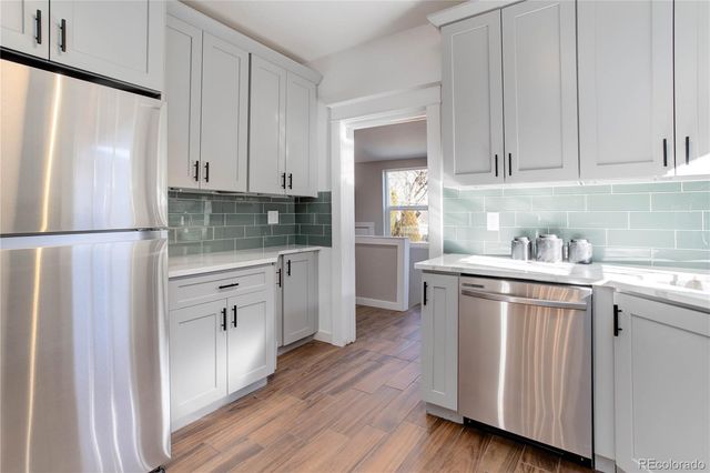 a kitchen with white cabinets and white appliances
