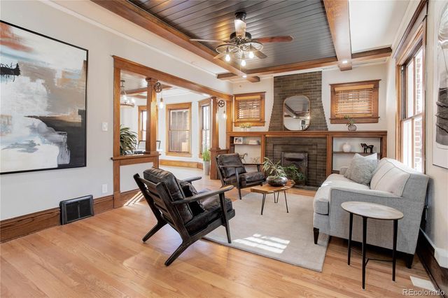 a living room with fireplace furniture and a large window