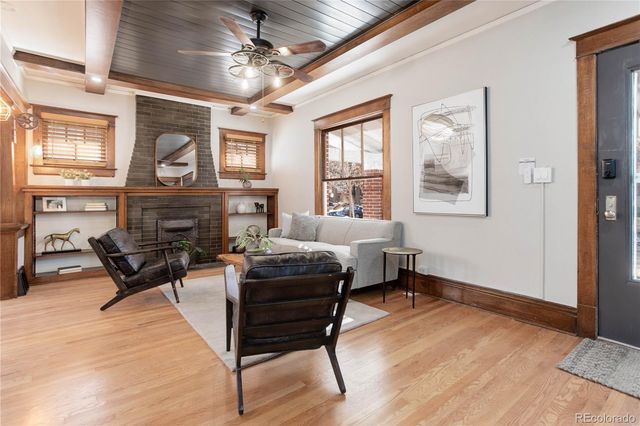 a living room with furniture a fireplace and a window
