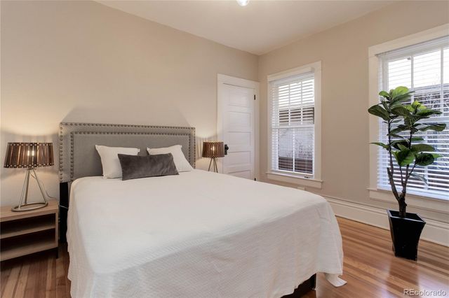 a bedroom with bed and wooden floor