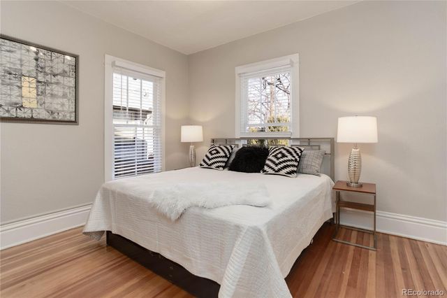a bedroom with a large bed and wooden floor