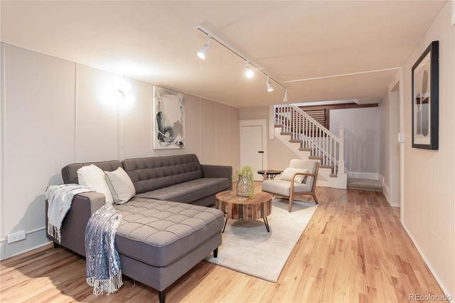 a living room with furniture and a wooden floor