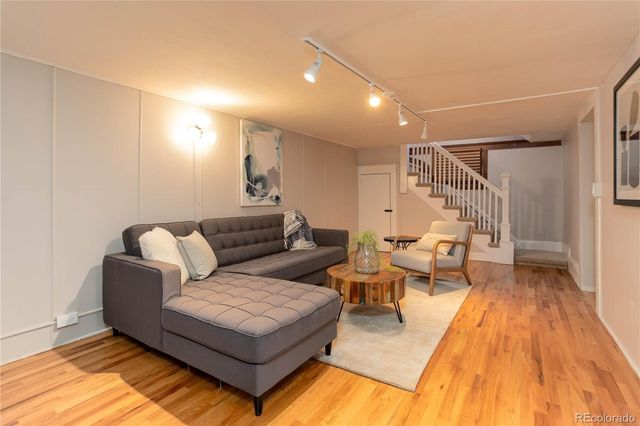 a living room with furniture and a wooden floor