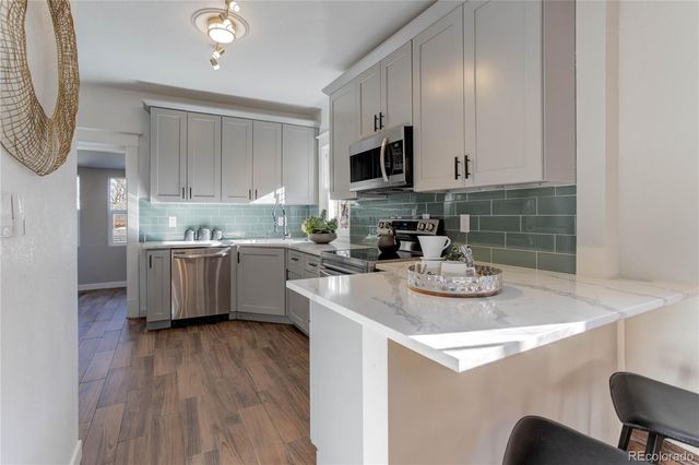 a kitchen with stainless steel appliances a sink a stove top oven a counter space and cabinets