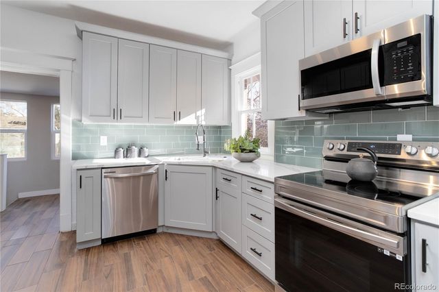 a kitchen with stainless steel appliances granite countertop a stove a sink and a microwave