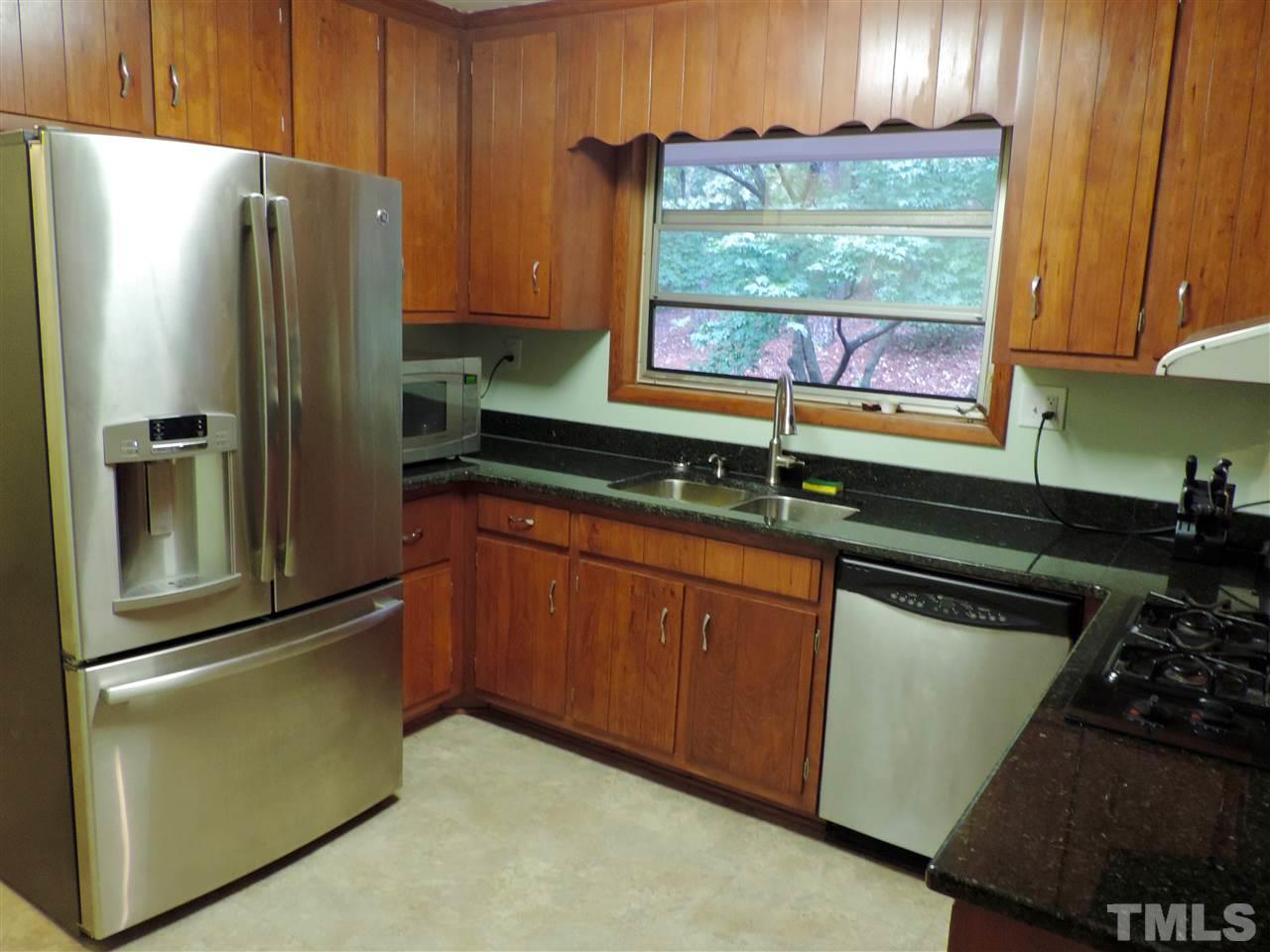 1303 Lorimer Road Raleigh, NC 27606 - Photo 3 of 13 a kitchen with granite countertop a refrigerator and a sink