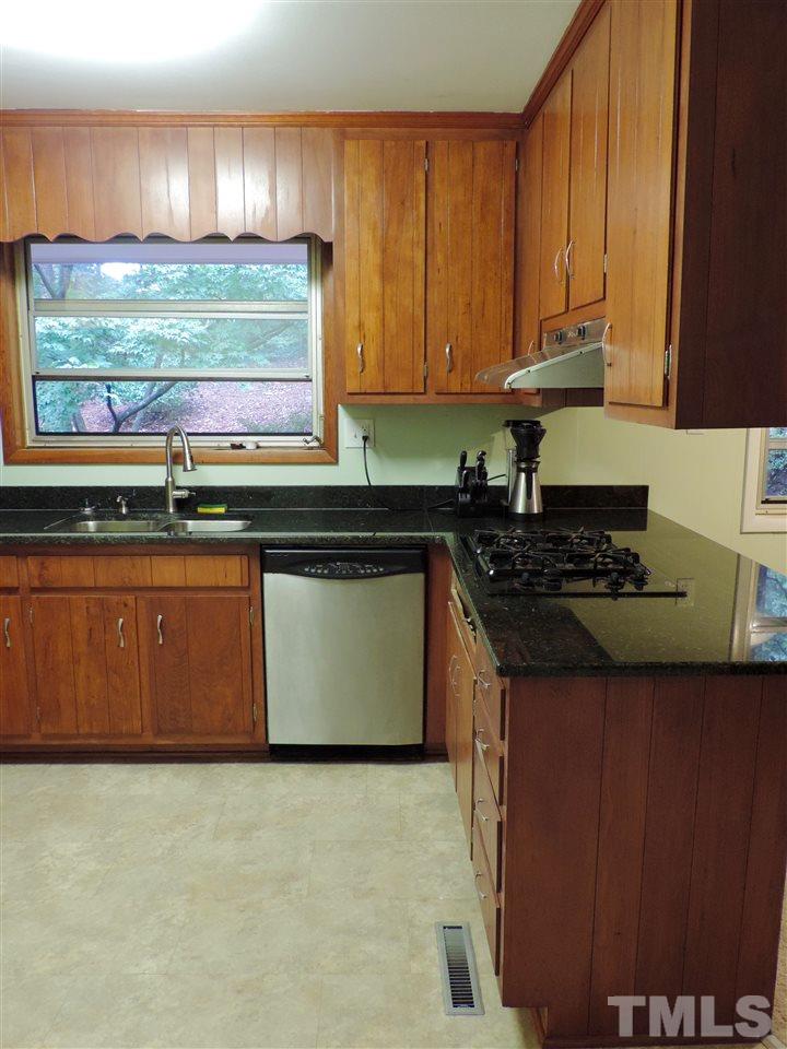 1303 Lorimer Road Raleigh, NC 27606 - Photo 4 of 13 a kitchen with stainless steel appliances granite countertop a stove a sink and a microwave