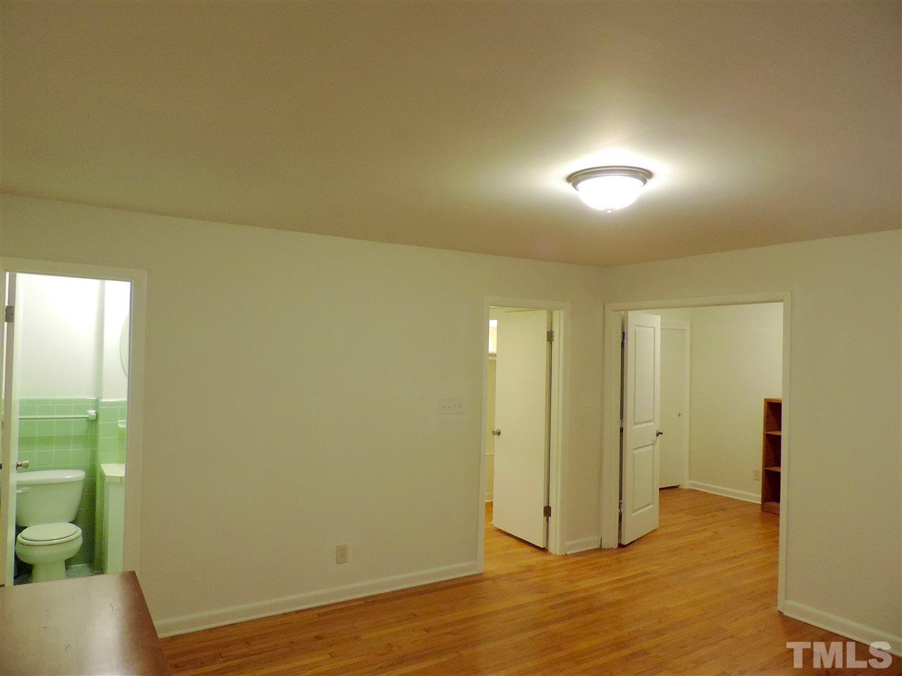 1303 Lorimer Road Raleigh, NC 27606 - Photo 8 of 13 an empty room with wooden floor and windows