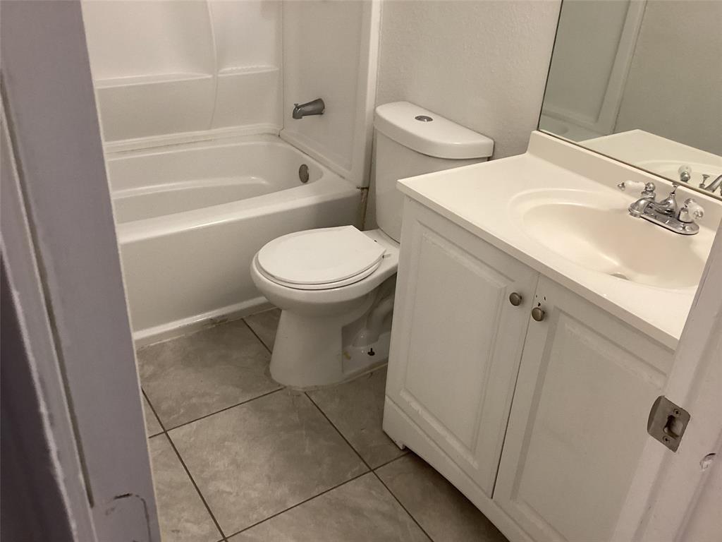 a white toilet sitting next to a bathroom sink and vanity
