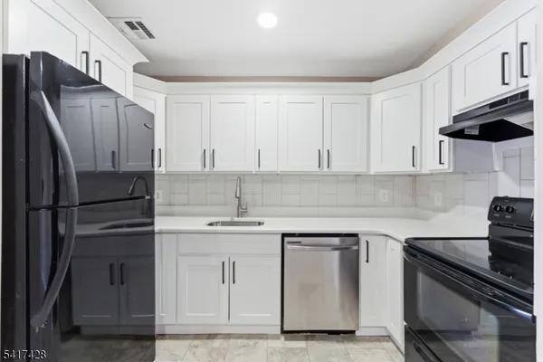 a kitchen with stainless steel appliances granite countertop a refrigerator sink and stove