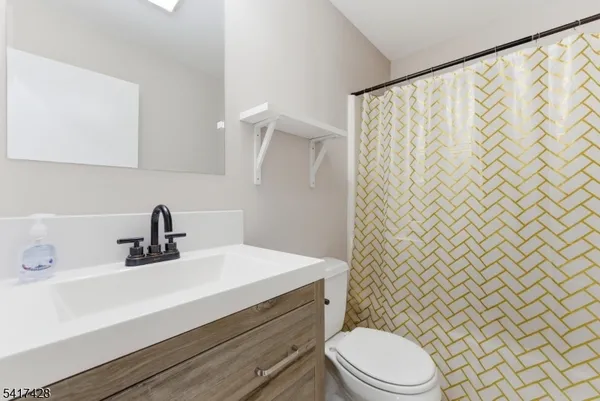a bathroom with a sink a toilet and shower curtain