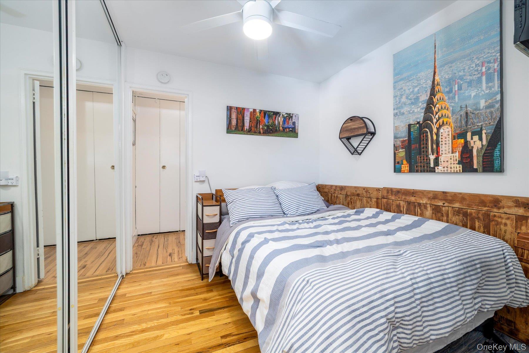 522 Shore Road, Unit 4A Long Beach, NY 11561 - Photo 11 of 32 a bedroom with a bed and a chandelier