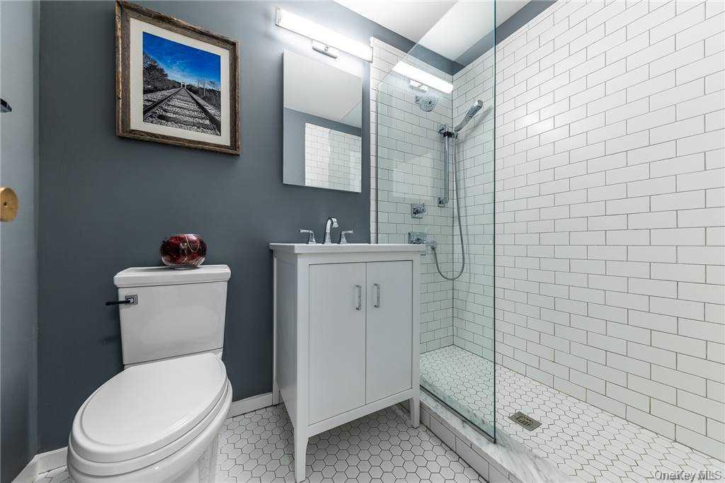 522 Shore Road, Unit 4A Long Beach, NY 11561 - Photo 13 of 32 a white toilet sitting next to a bathroom sink