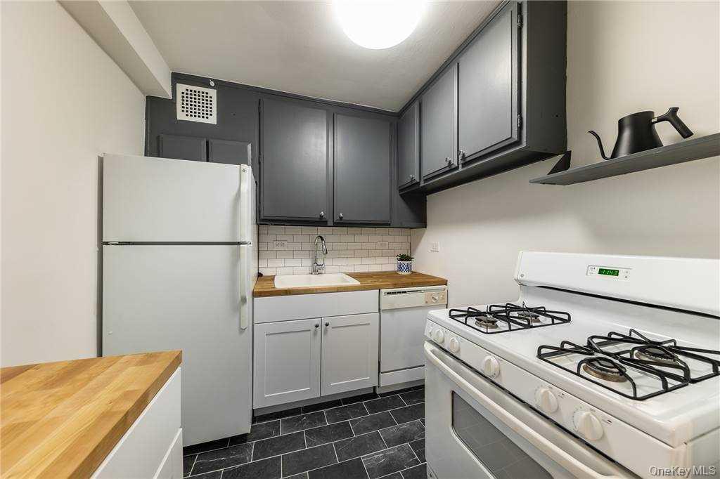 522 Shore Road, Unit 4A Long Beach, NY 11561 - Photo 10 of 32 a kitchen with a stove and a refrigerator