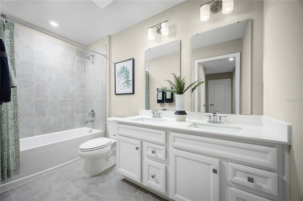 31391 Spanish Msn Road San Antonio, FL 33576 - Photo 13 of 26 a bathroom with a double vanity sink toilet mirror and bathtub