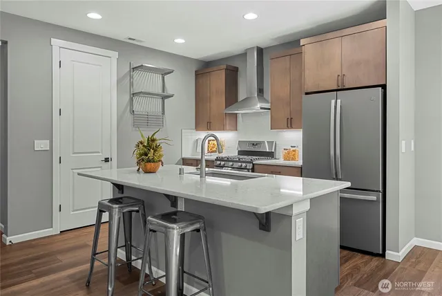 a kitchen with kitchen island a refrigerator stove and microwave