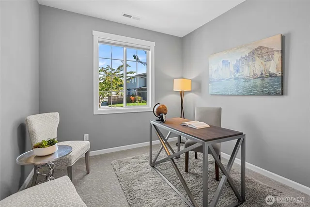 a view of a workspace with furniture and a window