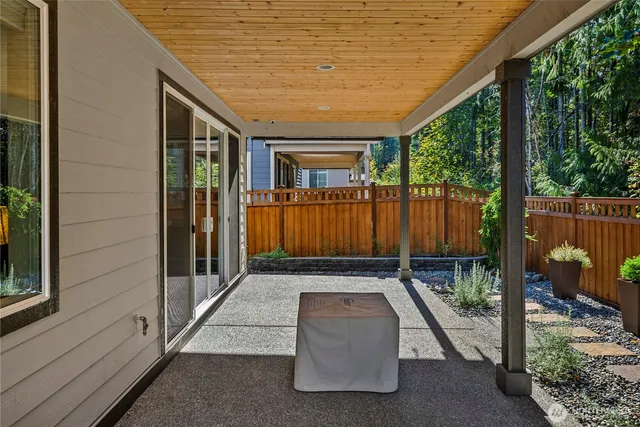 a view of a patio with table and chairs with wooden floor and fence