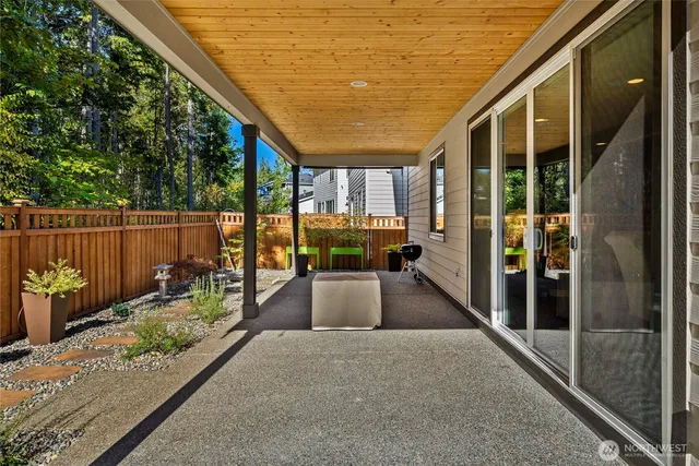 a view of a porch with chairs and floor to ceiling window