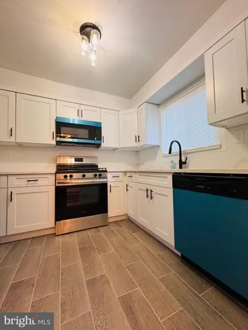 a kitchen with stainless steel appliances granite countertop a sink a stove top oven and cabinets