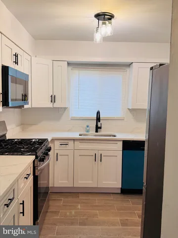 a kitchen with white cabinets and appliances